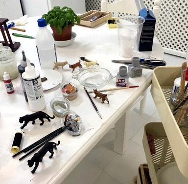 Mesa de trabajo de divARTsity con miniaturas y materiales de pintura